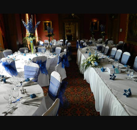 Blue sashes on white linen set as top table at Crathorne Hall