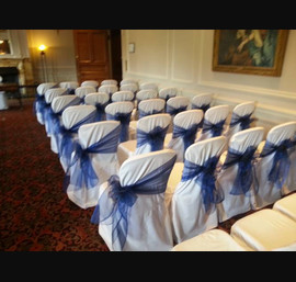 Navy blue organza sashes on white linen at Crathorne Hall