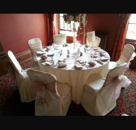 Dusky pink and champagne double bows on butter linen at Crathorne Hall