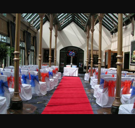 Burnt Orange Bows and Royal Blue Alternating on White Chair Covers in the Orangery
