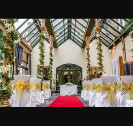 White Chair Covers with Gold Organza Bows in the Orangery - Photo by Stan Seaton