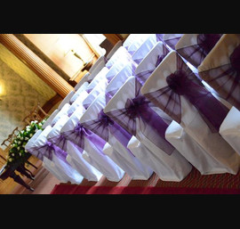 White chair covers with cadbury purple organza sash at Goldsborough