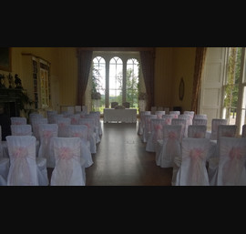 White chair covers with pink organza sashes with lace inserts at Swinton park