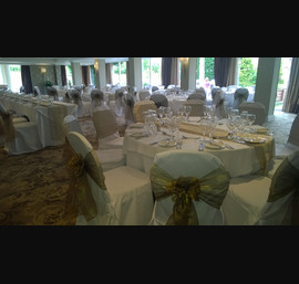 White chair covers with bronze organza sashes and matching table runners at The Bridge Hotel