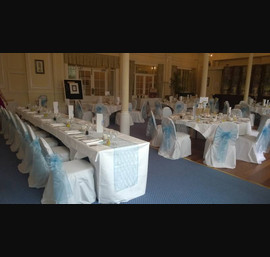 Light blue Organza sashes on white chair covers at the Cairn Hotel