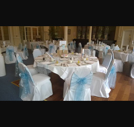 Light blue Organza sashes on white chair covers at the Cairn Hotel