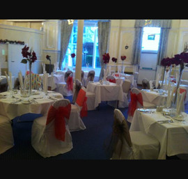 Red and Bronze organza sashes on white chair covers at The Cairn Hotel, Harrogate