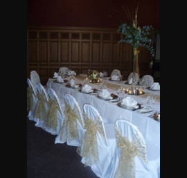 Gold embroidered organza sashes on white chair covers at The Crown Hotel, Harrogate