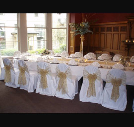 Gold embroidered organza sashes on white chair covers at The Crown Hotel, Harrogate