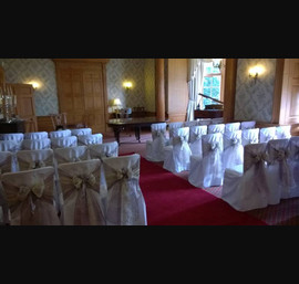 Dusky pink and champagne flocked organza sashes on white chair covers at Goldsborough Hall