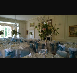 Peacock and light blue organza sashes on white chair covers at Goldsborough Hall