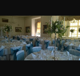 Peacock and light blue organza sashes on white chair covers at Goldsborough Hall