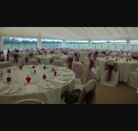Aubergine organza sashes on white chair covers at Boroughbridge wedding