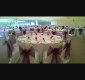 Aubergine organza sashes on white chair covers at Boroughbridge