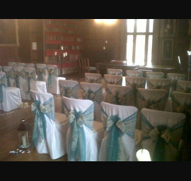 Teal organza and Champagne flocked double sashes on white chair covers at Ripley Castle