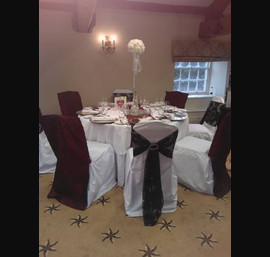 Burgundy pintook Chair Veils and black flocked sashes on white chair covers at Ripley Castle