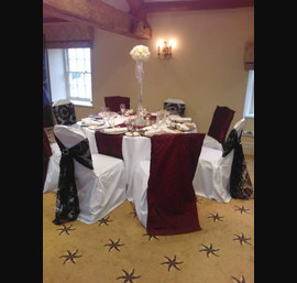 Burgundy pintook Chair Veils and black flocked sashes on white chair covers at Ripley Castle