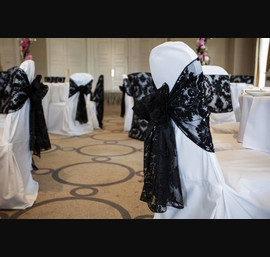 Black Flocked organza sash and chair veil on white chair covers at Rudding Park photograph by baughanphotography.co.uk
