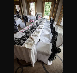 Black Flocked organza sash, table runner and chair veil on white chair covers at Rudding Park. photograph by baughanphotography.co.uk