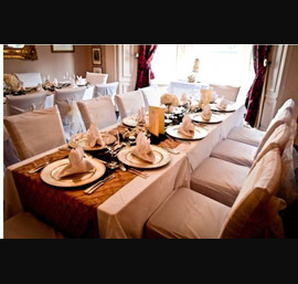 Champagne sashes on white chair covers. Gold pintuck and black flocked organza table runners at William and Victorias Harrogate