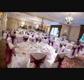 Aubergine Organza sashes on white chair covers, at Wood Hall Hotel, Linton