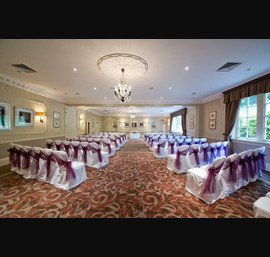Aubergine Organza sashes on white chair covers, at Wood Hall Hotel, Linton