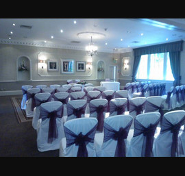 Aubergine Organza sashes on white chair covers, at Wood Hall Hotel, Linton