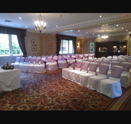Aubergine Organza sashes on white chair covers, at Wood Hall Hotel, Linton