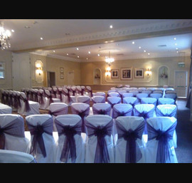 Aubergine Organza sashes on white chair covers, at Wood Hall Hotel, Linton