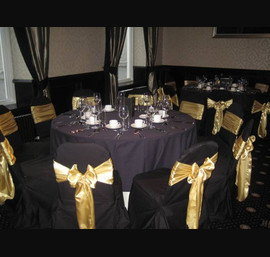 Gold Satin Sashes on Black Chair Covers at Rox Hotel