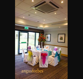 Multi coloured single sash on white chair cover at Double Tree Hilton