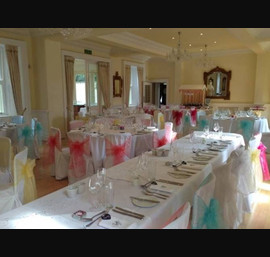 Multi coloured bow on white chair cover