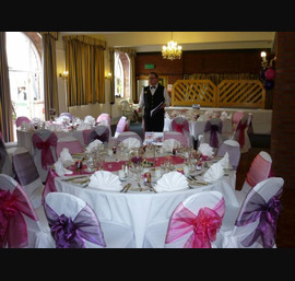 Alternate raspberry and cadburys purple single sash on white chair covers