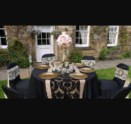 hampagne flock sash on black chair covers with opposite colour table runner