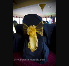 Gold single bow on black chair cover at Forbes of Kingennie
