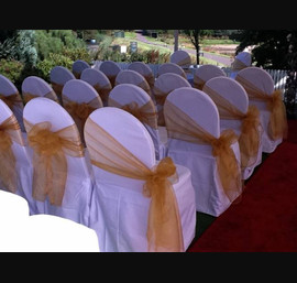 Gold single bow with side aisle bow on white chair cover at Forbes of Kingennie