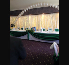 Emerald green satin top table swagging with bows