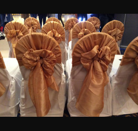 Gold satin hoods on white chair cover