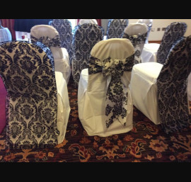 Black flock hood alternated with flock taffeta bows on white chair covers