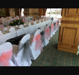 Silver and pale pink organza bows on white chair covers