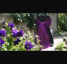 Black chair covers with Cadbury purple sash & pearl accessory