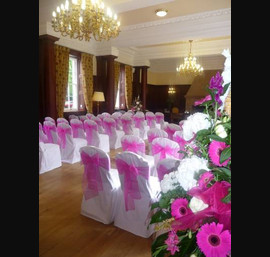 White Chair Covers and fushia pink bows at Doxford Hall