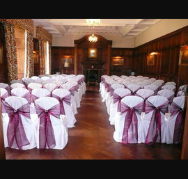 White Chair Covers with Wine bows with silver broaches at Ellingham Hall