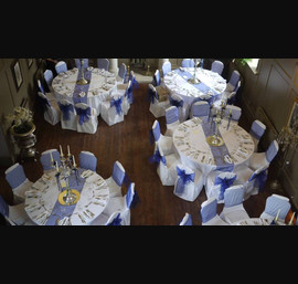 White Chair Covers with Midnight blue bows at Ellingham Hall. Flowers by Secret Garden