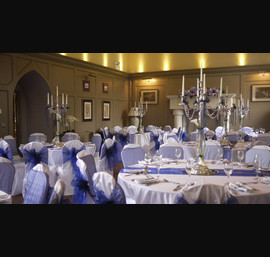 White Chair Covers with Midnight blue bows at Ellingham Hall. Flowers by Secret Garden