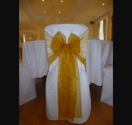 White Chair Covers and Bright gold bows at Eshott Hall