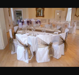 Bronze sashes on white chair covers at Eshott Hall
