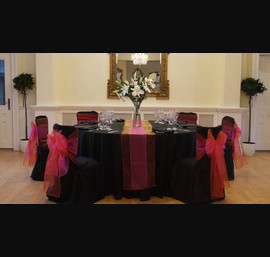 Black linen and bright orange & pink double bows at Eshott Hall