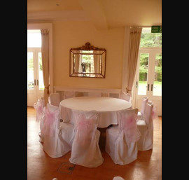 White Chair Covers and Baby Pink Bows at Eshott Hall