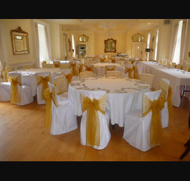 White Chair Covers and Gold Bows at Eshott Hall